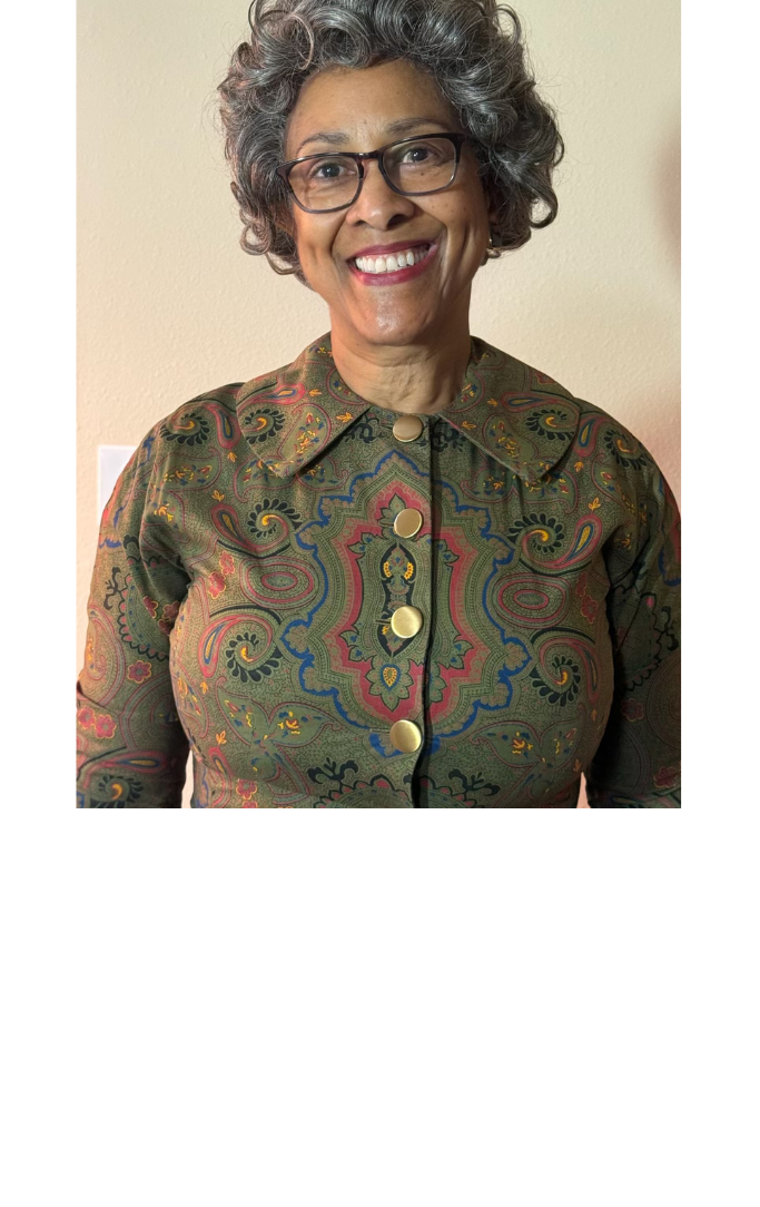 Older lady with glasses and a green dress smiling