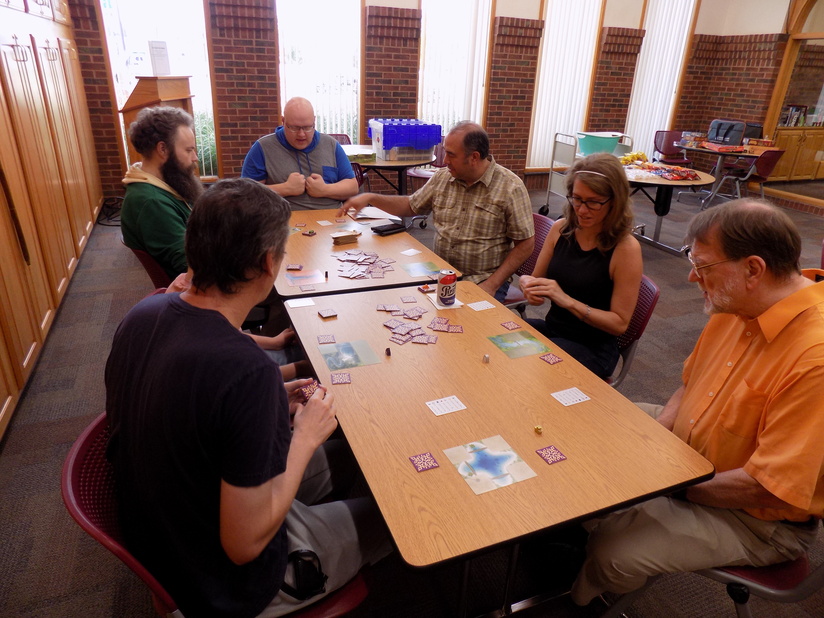 Group of adults sitting around a table playing a game